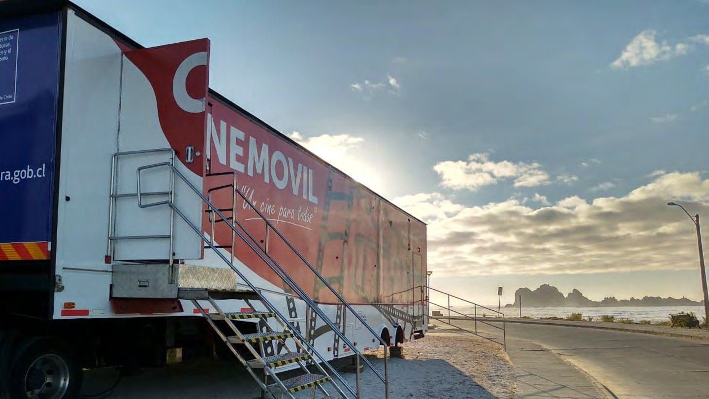 El camión de Cinemóvil desplegado frente al mar al atardecer